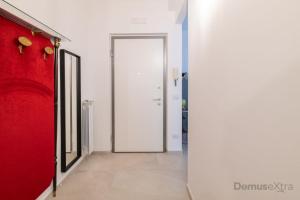那不勒斯Clara Domus By DomusExtra的一条走廊,有红色的门和红色的墙壁