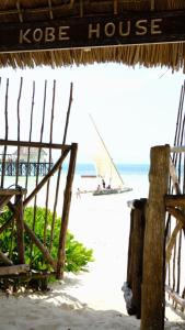 江比阿科比住宿加早餐旅馆的海滩上有一个圆顶屋,水中还有一条船