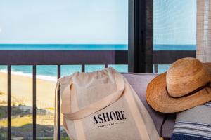 大洋城Ashore Resort & Beach Club的戴帽子的人坐在沙发上,带袋子