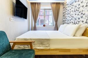 伊斯坦布尔Charming Balat Haven Idyllic Location in Balat的一间卧室配有一张床和一把绿色椅子