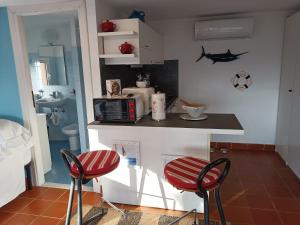 卡莫利Casetta Mami的厨房配有2把红色椅子和台面