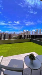 乔治市2BR Georgetown Luxury Suite #RoofTopPool #Beacon的一个带桌椅的庭院和一个绿色草坪
