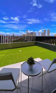 乔治市2BR Georgetown Luxury Suite #RoofTopPool #Beacon的一个带桌椅的庭院和一个绿色的田野。
