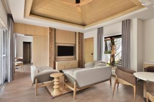 马迪凯里Coorg Marriott Resort & Spa的客厅配有沙发、椅子和电视