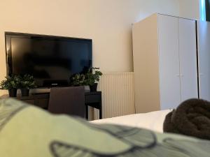 埃因霍温Room 101 - Eindhoven的一间卧室设有平面电视和一张床。