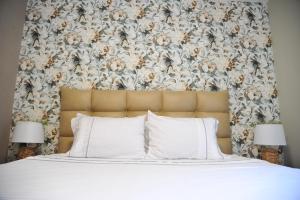 弗尔尼亚奇卡矿泉镇Apartman Ljubica的一张带白色枕头和花卉床头板的床