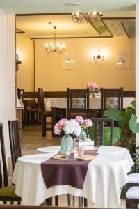 切佩拉雷米特奥家庭酒店的用餐室,配有鲜花桌