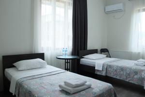 库塔伊西Hotel West Face的酒店客房设有两张床和一张桌子。