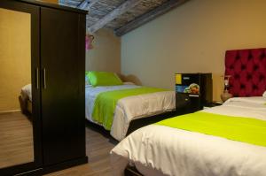 昆卡Casa Suite Campana的一间卧室配有两张带绿色和白色床单的床
