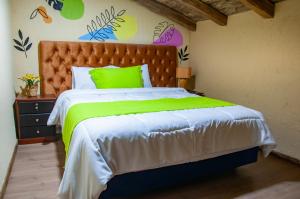 昆卡Casa Suite Campana的一间卧室配有一张大床和绿色的床罩