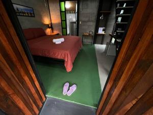 春蓬เป่าฟู่เฮ้าส์ Bao Fu's House的一间设有一张床和一双拖鞋的房间