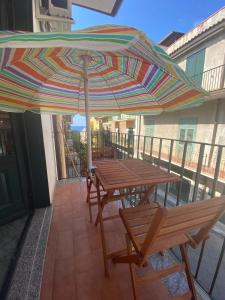 焦约萨马雷阿Dimora Zefiro vacanze的阳台配有桌椅和遮阳伞