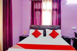 巴特那Flagship Hotel The Pinkcity的卧室配有红色和白色的床和红色枕头