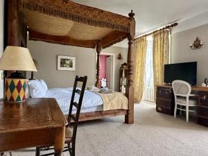 谢普顿马利特Montigo Resorts, Somerset的一间卧室配有一张天蓬床、一张桌子和一张书桌