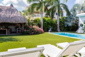 简蒂埃尔Stylish 4 Bedroom Modern Villa Design, Walking Distance From The Beach的一个带游泳池和棕榈树的度假庭院