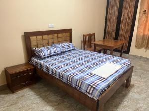 达喀尔CHAMBRES PRIVEE-APPARTEMENT VUE SUR MER的卧室配有1张床、1张桌子和1把椅子