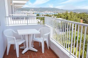 圣安东尼奥湾Hotel Apartamentos Vibra Monterrey的阳台上配有一张白色的桌子和两把椅子