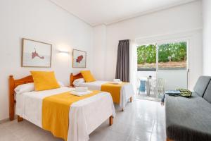 圣安东尼奥湾Hotel Apartamentos Vibra Monterrey的酒店客房,设有两张床和一张沙发
