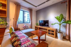 岘港Taian Hotel & Apartment的带沙发和电视的客厅
