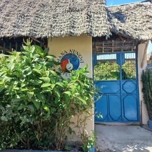 南威MaNa Nungwi的蓝色门和茅草屋顶的房子