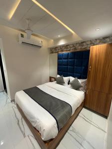 艾哈迈达巴德Hotel Paragon villa的一间卧室配有一张大床和一个木制橱柜