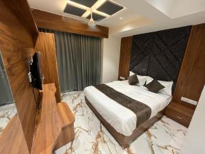 艾哈迈达巴德Hotel Paragon villa的一间卧室配有一张床和一台电视