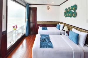 下龙湾Halong Sapphire Cruises的带阳台的酒店客房内的两张床