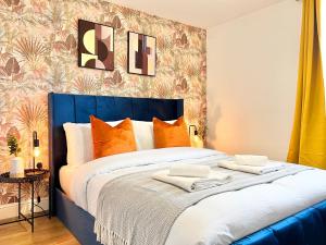 伦敦2 Modern Double Bed Apartment for 6 Guests By Hofin Stays Short Lets & Serviced Accommodation的一间卧室配有带橙色枕头的大型蓝色床