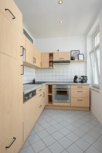 施科伊迪茨LE Vacation 3-Room-Apartment 67qm, Küche, Netflix, Free-TV的厨房配有木制橱柜和白色瓷砖地板。