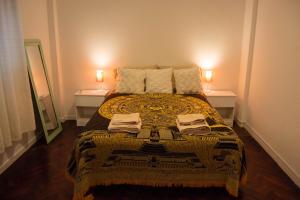 布宜诺斯艾利斯Acogedor Monoambiente en Palermo的一间卧室配有一张带两张桌子和两盏灯的床。