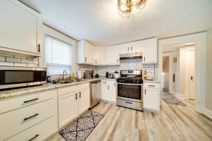 米德维尔Meadville Apartment with Deck Less Than 2 Mi to Allegheny!的厨房配有白色橱柜和炉灶烤箱。
