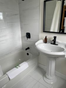 Port DufferinThe Marmalade Motel的白色的浴室设有水槽和浴缸。