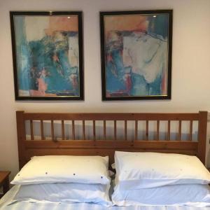 德里门Annexe Lodge cottage in Drymen的一张带两个枕头的床和墙上的两张照片