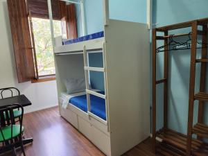 圣保罗Fujima Hostel的客房设有双层床和桌子。