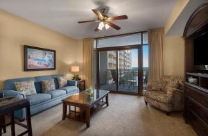 默特尔比奇North Beach Resort & Villas的客厅配有蓝色的沙发和吊扇
