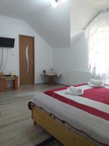 波若勒塔Pensiunea Gură de Rai, Pojorâta的一间卧室配有一张带红白毯子的床