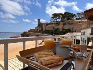 滨海托萨Hostal del Mar的一张桌子,上面放着一盘食物和两杯橙汁