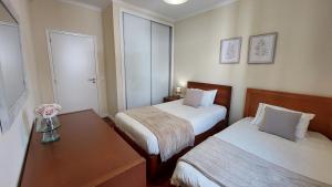 丰沙尔Villa Strelitzia的酒店客房设有两张床和一张桌子。