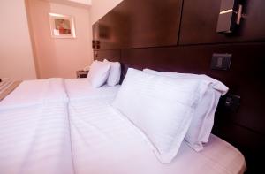 库马西Noble House Hotel的一间卧室配有两张带白色床单和枕头的床。