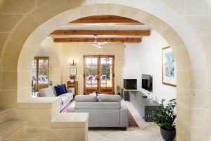 加斯利Dar ta' Lonza Villa with Private Pool的带沙发的客厅的拱门