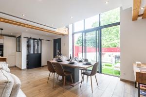 马尔桑奈拉科特Charmante Maison Climatisée avec son Jardin à 10 minutes de DIJON的用餐室以及带桌椅的起居室。