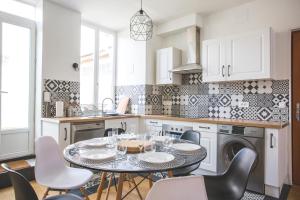 图尔昆Colocation de luxe à Tourcoing avec jardin的厨房配有桌椅和水槽