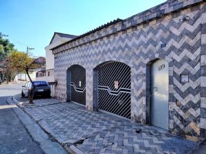 瓜鲁柳斯Pousada Guarulhos的一座建筑,设有两个车库门和一个停车计费器