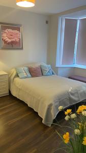 贝克斯希尔Bexhill Stunning 2 bedroom Sea Front Bungalow的一间卧室配有一张带窗户和鲜花的床