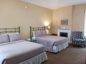MaysvilleLee House Inn的酒店客房设有两张床和壁炉