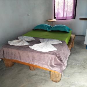 PortelaPensao Zé Doce的一张带绿色床单和枕头的床