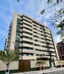 马塞约Apartamento Maceió - De frente a Praia de Jatiuca的一座高大的公寓楼,前面有棕榈树