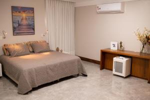 维多利亚Casa 4 Suítes - Ilha do Boi的一间卧室配有一张床和一台电视。