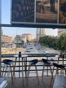 普里什蒂纳Hotel City Rooms Prishtina的阳台配有2张桌子和椅子,街道上