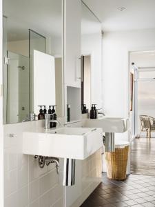 比那隆湾Holland House Bay of Fires的白色的浴室设有两个盥洗盆和镜子